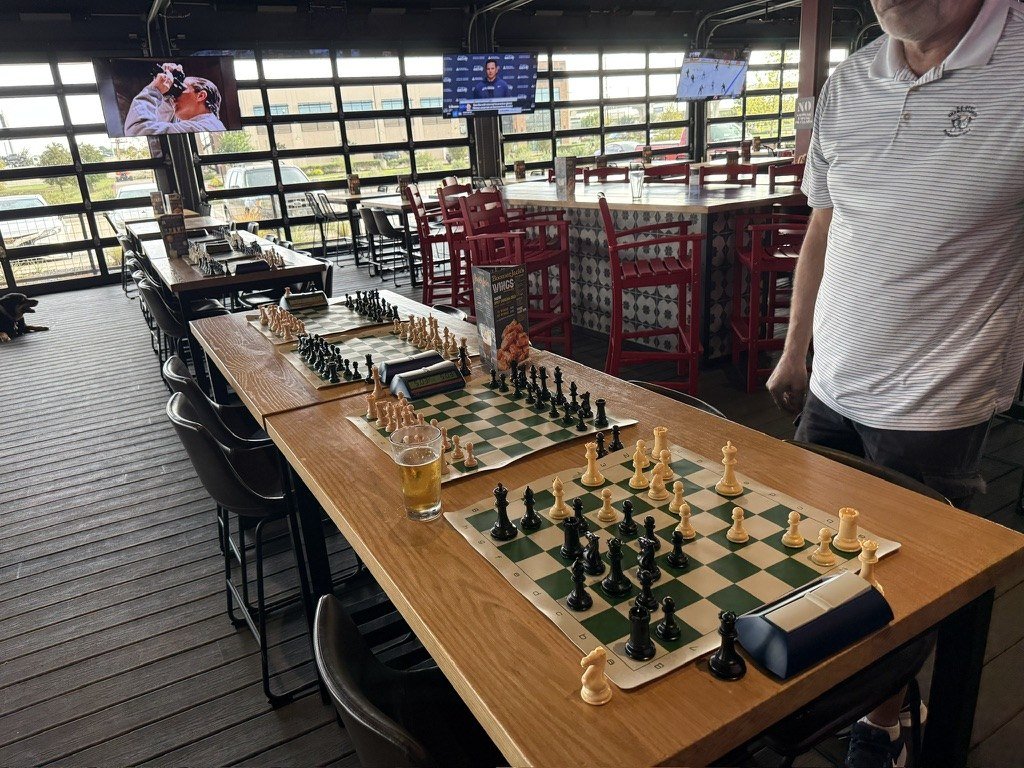 Chess boards and clocks set up on the patio at Boomerjack's Katy
