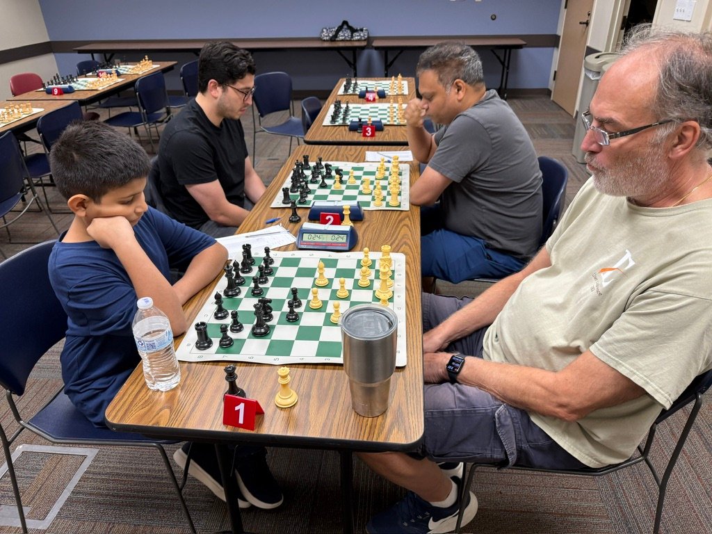 A junior player studies Board 1 while his opponent looks on