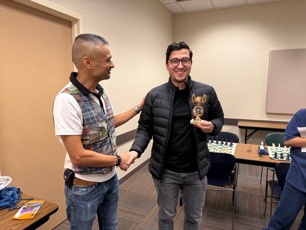 David holds the champion's trophy while shaking hands with Jay
